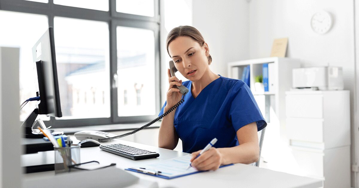 A medical professional giving advice to a patient over the phone while taking notes during a confidential pregnancy consultation about abortion risks and available pregnancy services.